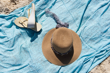 hat and canga on the beach sand with the sea in the background