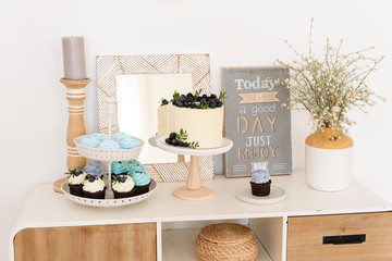 Rustic, boho candy bar. Table with cake, cupcakes and different sweets for party. Birthday party. Confectionery, bakery concept