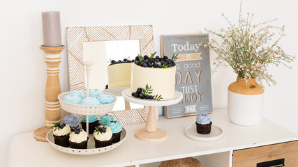 Birthday party. Boho candy bar with cake, cupcakes and different sweets.