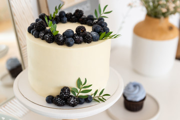 Wedding, birthday cake with cream cheese and fresh blueberries and blackberries. Close up.