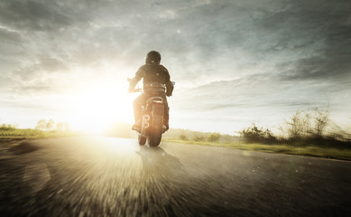 Biker mit Motorrrad auf einer Landstraße 