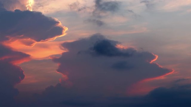 Orange, pink, violet and blue Sunset clouds fast moving over the sky. Dramatic Timelapse. FULL HD
