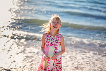 Happy child running and jumping in the waves during summer vacation on exotic tropical beach. Holiday on ocean coast for family with young children. Kids play at the sea