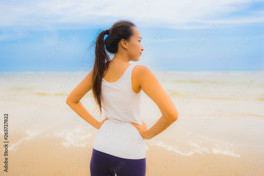 Wall mural Portrait beautiful young sport asian woman exercise by run and jogging on the outdoor nature beach and sea