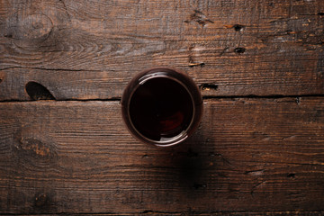 Glass of red wine on wooden table. View from top