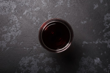 Glass of red wine on dark gray table. View from top