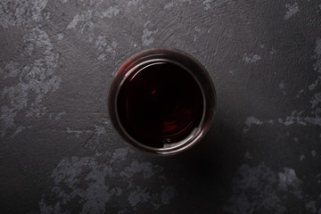 Glass of red wine on dark gray table. View from top