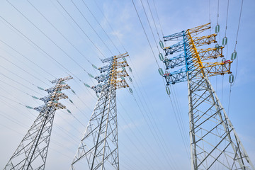 High voltage towers in the blue sky white cloud background