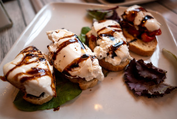 little bruschetta appetizers on a white plate