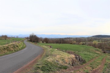 Paysage de campagne en Haute Loire avec des monts en arrière plan - France