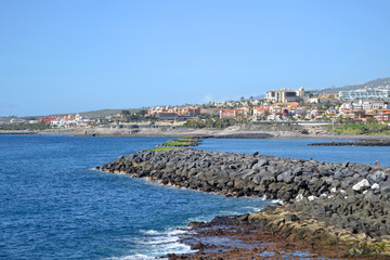 Wave breakers. Costa Adeje, Tenerife, Canary Islands. Seacoast and blue ocean on a sunny day.  