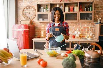 Black woman in apron cooking healthy breakfast