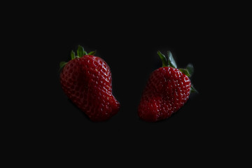 Fresh strawberries on a black background. Horizontal orientation