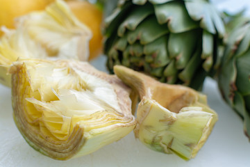 Preparation of heads of fresh raw artichokes plants from artichoke plantation in Argolida, Greece ready to cook with lemon
