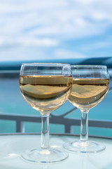 White wine served outside on balcony on glass table with sea view