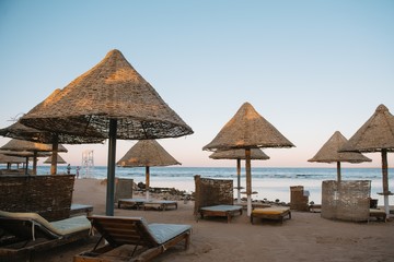 Lounge chairs and straw umbrellas at the beach in Malaga. Costa del Sol, Andalusia, Spain