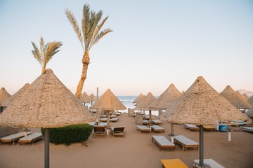 Lounge chairs and straw umbrellas at the beach in Malaga. Costa del Sol, Andalusia, Spain