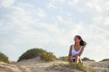 young woman sitting in the dunes