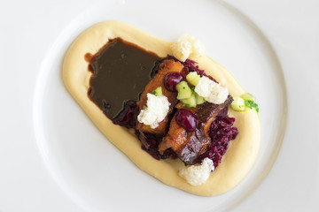 Main course, dish with roasted pork belly, red sauerkraut and mashed potatoes. Demonstration cooking. Top view.