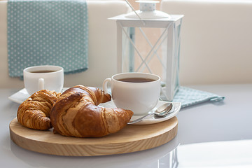 Tasty breakfast for two with fresh croissants and hot herbal tea.