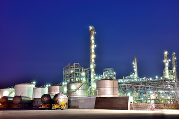The oil truck tankers in the refinery background in the evening