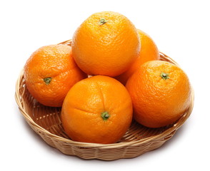 Ripe orange in wooden wicker basket isolated on white background