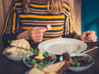Woman eating tapas in restaurant