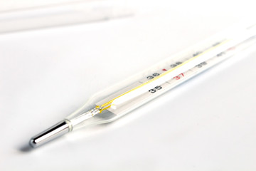 Glass mercury thermometer with celsius degree. Thermometer close-up on white background