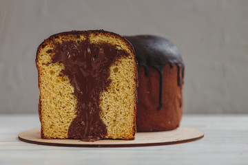 Happy Easter background with an easter bread cake decorated with glaze, chocolate and  eggs. For greeting card, ad, promotion, poster, flyer. complex composition, beautiful scenery, movement, hands