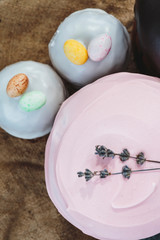 Happy Easter background with an easter bread cake decorated with glaze, chocolate and  eggs. For greeting card, ad, promotion, poster, flyer. complex composition, beautiful scenery, movement, hands