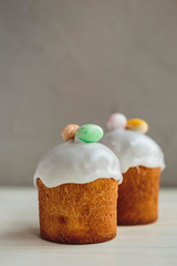 Happy Easter background with an easter bread cake decorated with glaze, chocolate and  eggs. For greeting card, ad, promotion, poster, flyer. complex composition, beautiful scenery, movement, hands