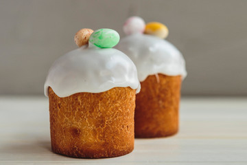 Happy Easter background with an easter bread cake decorated with glaze, chocolate and  eggs. For greeting card, ad, promotion, poster, flyer. complex composition, beautiful scenery, movement, hands