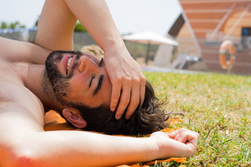 young man sunbathing in the pool