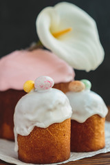 Happy Easter background with an easter bread cake decorated with glaze, chocolate and  eggs. For greeting card, ad, promotion, poster, flyer. complex composition, beautiful scenery, movement, hands