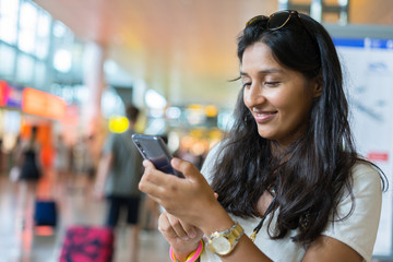 young indian woman typing a message