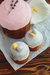 Happy Easter background with an easter bread cake decorated with glaze, chocolate and  eggs. For greeting card, ad, promotion, poster, flyer. complex composition, beautiful scenery, movement, hands