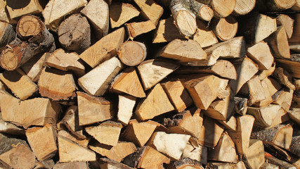Firewood stacked wooden wall background closeup.