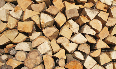 Firewood stacked wooden wall background closeup.
