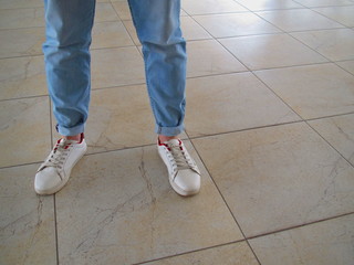  Men's legs in stylish jeans in the hall