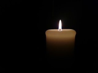 Burning candle in the dark