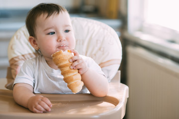 baby in the kitchen eagerly eating the delicious cream horns, filled with a vanilla cream