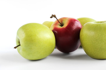 Red apple standing on group of green apples. Green and red apples isolated on white background.