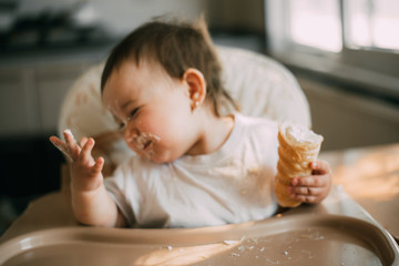 baby in the kitchen eagerly eating the delicious cream horns, filled with a vanilla cream