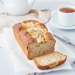 Banana bread, cake with banana, side view, vertical. The morning Breakfast with tea on a light grey background