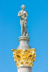 Ancient statue covered with moss and lichen of a sensual renaissance era woman in Potsdam, Germany