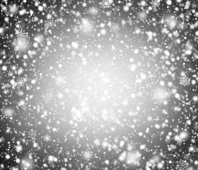 Abstract winter design. Festive concept with falling snowflakes on dark gray background. Light in the middle.