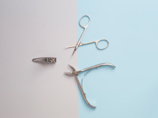 Nail care. Manicure professional accessories. Steel tools of manicure set isolated on blue background. The concept of beauty. Medical tools.