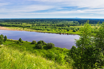 river, forest and mountain in the distance on a summer day