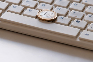 Online business. The concept of on-line sales. Coin in one Euro on the computer keyboard close-up....
