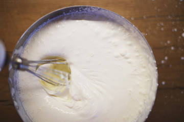 cream is whipped with a mixer in a bowl